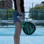 A person on a padel court ready to serve