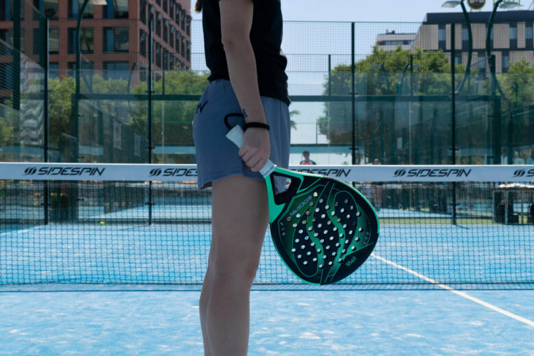 A person on a padel court ready to serve