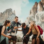 Four travellers laughing in front of some big rocks