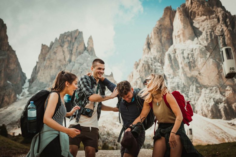 Four travellers laughing in front of some big rocks
