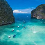 small boats on a Thailand shore in blue waters