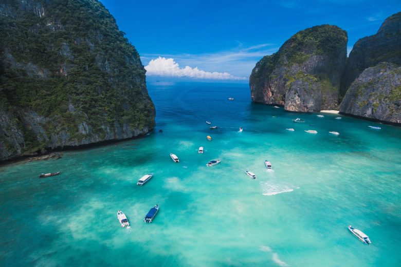 small boats on a Thailand shore in blue waters
