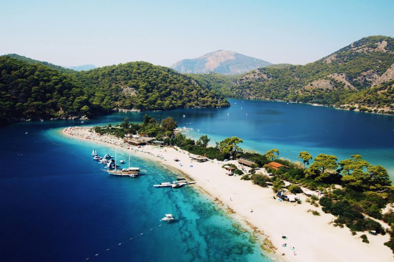 A beach in Dlaman Turkey surrounded by striking blue waters.